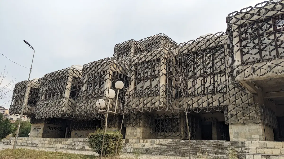Nationale Bibliotheek met kenmerkende koepels en metalen gevelrooster, Pristina